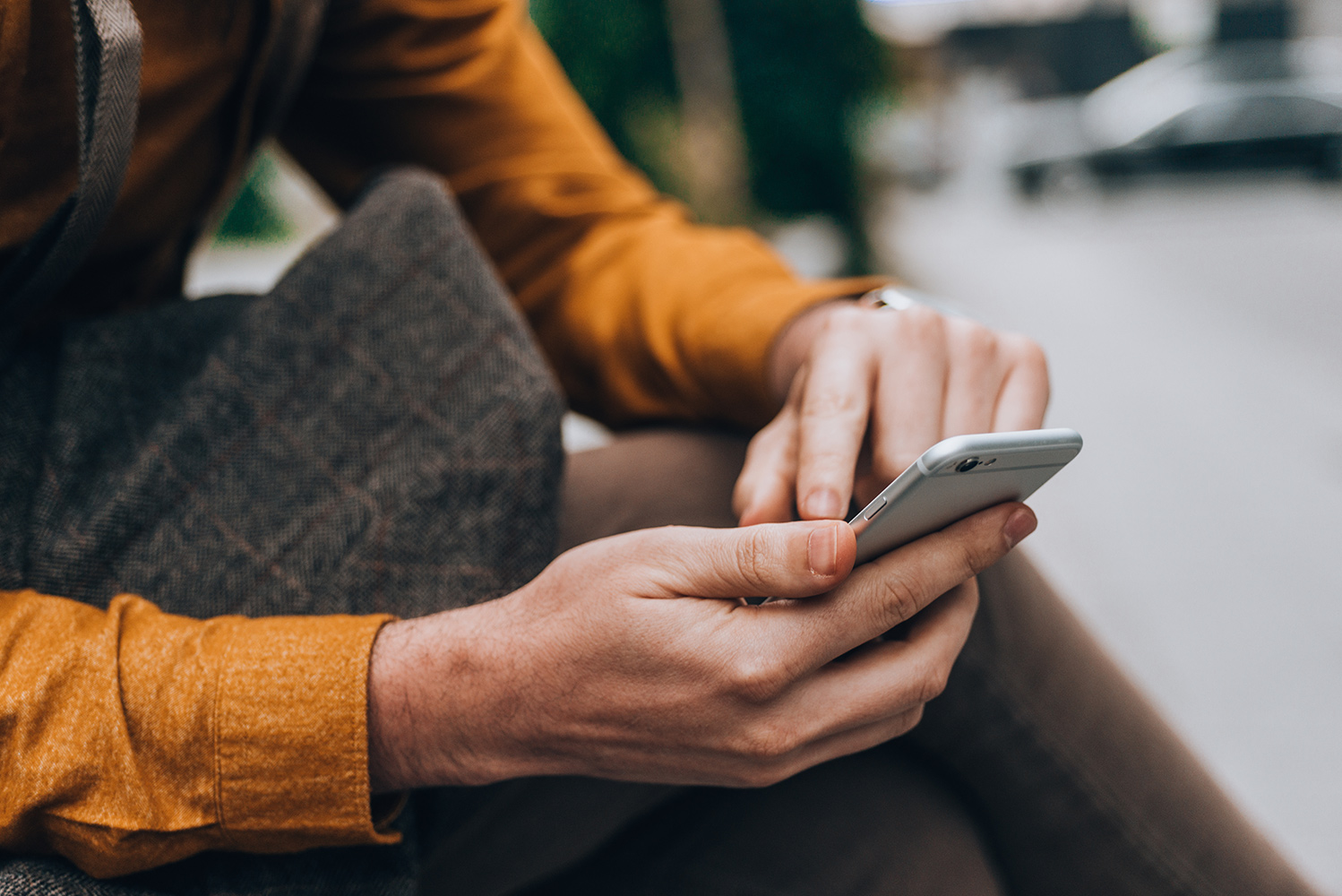 Junger Mann schaut auf sein Smartphone
